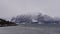 Small fishing boat on Lyngen fjord near Skibotn, Troms og Finnmark, Norway chased by a swarm of seagulls in winter.