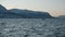 Small fishing boat with small wooden houses on the banks near fjords of Tromso in winter. Dark Blue water and mountains