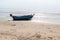 Small fishing boats aground on the beach with trees in the background