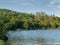 Small fishing boats on a lake Corrib, Ireland, Hill covered with trees, Blue cloudy sky