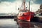 A small fishing or cargo ship on the dock in the port. The ship is waiting to sail. A vessel for fishing or transporting small