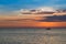 Small fishing ship over sunset seacoast skyline