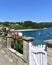 Small fishing village with boats and beach. View with white wooden door and flowers. Redes, Galicia, Spain.