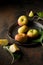 Small flattened apples on a metal tray on a dark