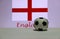 Small football on the white floor and English nation flag with the text of England background.