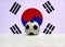 Small football on the white floor with red and blue Yin Yang and four black trigrams of South Korean nation flag background.