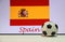 Small football on the white floor and Spanish nation flag with the text of Spain background.