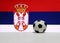 Small football on the white floor with white blue and red color, eagle and crown picture of Serbian nation flag background.