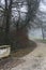 Small footbridge and a gravel path on a foggy day in a park