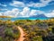 Small footpath to Spiaggia del dottore beach. Stunning morning scene of Sardinia island with Tavolara island on background, Italy,