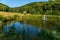 Small fountains in the middle of a lake in a lawn near high green mountains