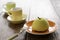 Small French ball shaped cakes mousse dome served on a plate with cups of tea