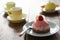 Small French ball shaped cakes mousse dome served on a plate with cups of tea