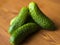 Small fresh cucumbers, small gherkins, baby cucumbers on a wooden cherry background