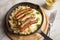 Small fried Bavarian German NÃ¼rnberger sausages with sauerkraut, mashed potatoes and mustard in iron cast pan on marble table