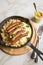 Small fried Bavarian German NÃ¼rnberger sausages with sauerkraut, mashed potatoes and mustard in iron cast pan on marble table