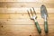 Small gardening shovel and fork on wooden background