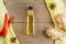 Small ginger oil bottle in center of keymap of condiments on yellow cloth on old wooden table.