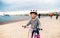 A small girl with bicycle cycling outdoors on beach.