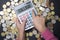 Small girl counting money for college with calculator and coins on dark background