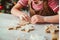 Small girl cutting out from rolled dough Christmas cookies. Holiday baking family celebration. Cozy homely atmosphere