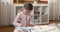 Small girl enjoy drawing using crayons at cozy child room