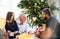 A small girl with father and grandfather sitting on a sofa at Christmas time, talking.