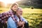 A small girl with grandfather outside in spring nature, relaxing on the grass.