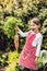 A small girl harvesting vegetables on allotment, holding a big carrot.