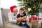 A small girl and her grandfather with Santa hat and a book at Christmas time.