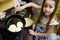 Small girl making pancakes. Mom teach daughter to cook