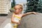 Small girl near a marble ball in a summer day