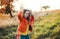 A small girl playing with a rainbow hand kite in autumn nature at sunset.