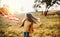 A small girl playing with a rainbow hand kite in autumn nature at sunset.