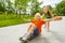 Small girl pushing happy boy on skateboard