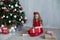Small girl in the red dress at the Christmas tree gifts new year holiday