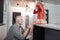 Small girl in a red dress sitting on a white table