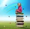 Small girl sits on the pile of books