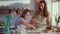 Small girl and woman sprinkling flour on table at modern kitchen