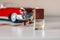 Small glass bottle with aromatic liquid. Car air freshener near toy car model