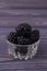 Small glass pot overfilled with blackberries.