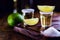 Small glass of tequila, fiery drink from mexico. Lemon, coarse salt on wooden background