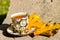 Small golden cup of tea on a saucer standing on a bench in the autumn the warm sunny day
