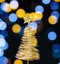 Small golden wire Christmas tree. Mini Christmas tree with bokeh light vintage background