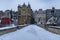 Small gothic bridge over Mlynowka river located at city center and covered by fresh snow at winter