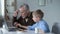 Small grandson showing grandfather how to use laptop, easy to learn software