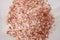 Small granules of pink Himalayan salt on a gray marble background