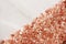 small granules of pink Himalayan salt on a gray marble background