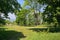 Small grassy football field between trees in czech town of Chabarovice with Ore mountains on background in spring