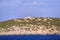 Small greek island on Mediterranean Sea, rocky islet with scant vegetation and traditional church chapel.